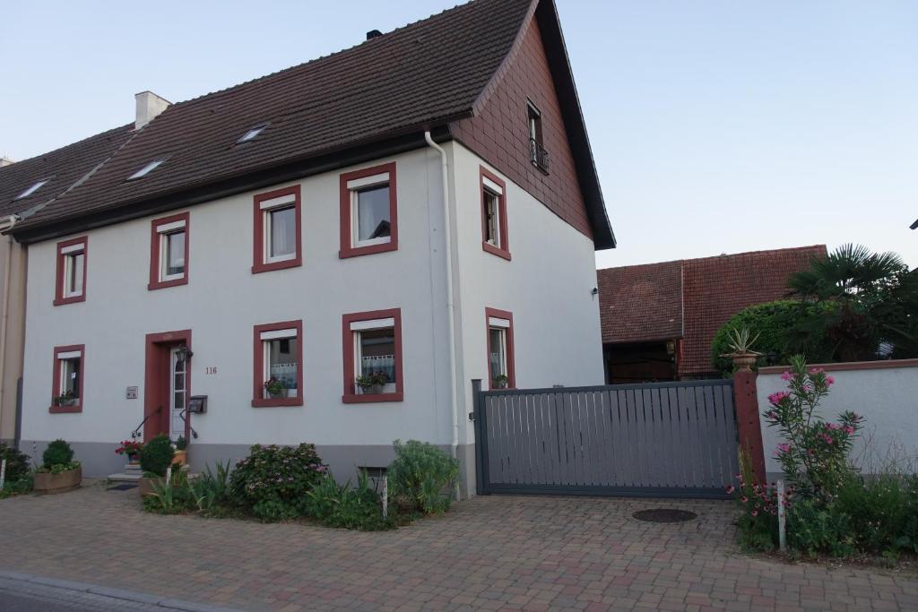 a white house with red windows and a fence at Ferienwohnung Fam. Höhn in Kappel-Grafenhausen