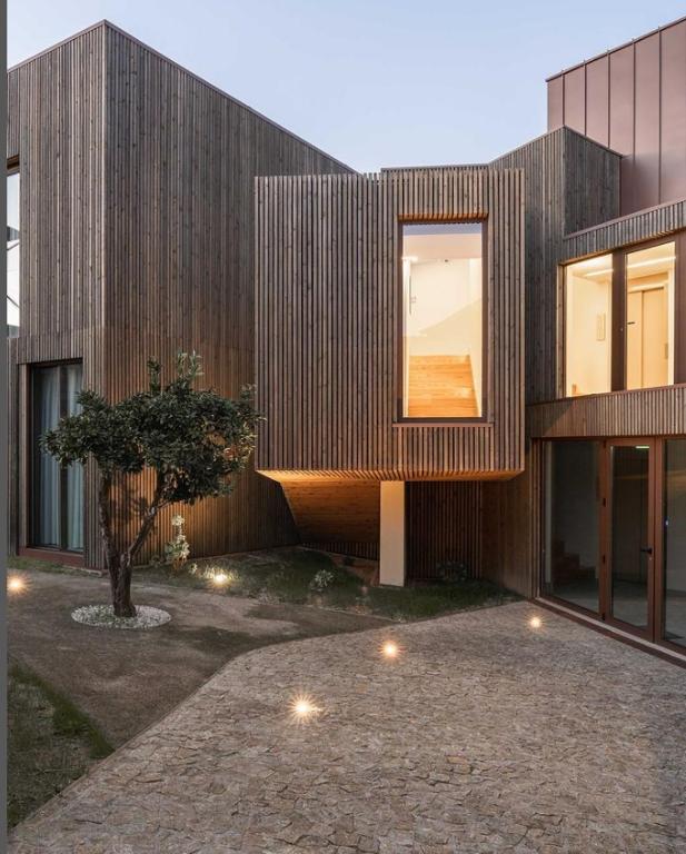 a wooden house with a tree in front of it at Villã - Casas de Campo in Paredes