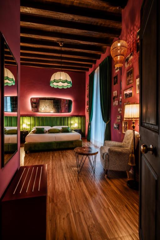 a bedroom with red walls and a bed and a table at Palazzo San Fedele - Como Suites in Como