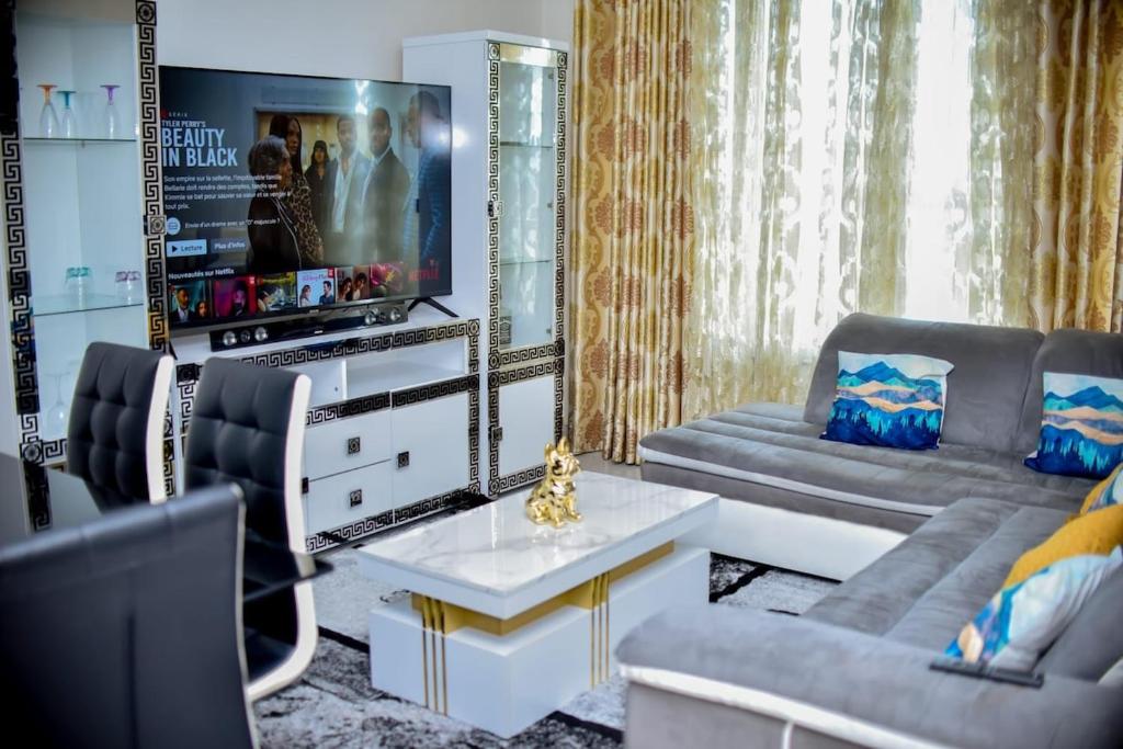 a living room with a couch and a tv at super apparemment pour vos vacances in Neuilly-sur-Marne