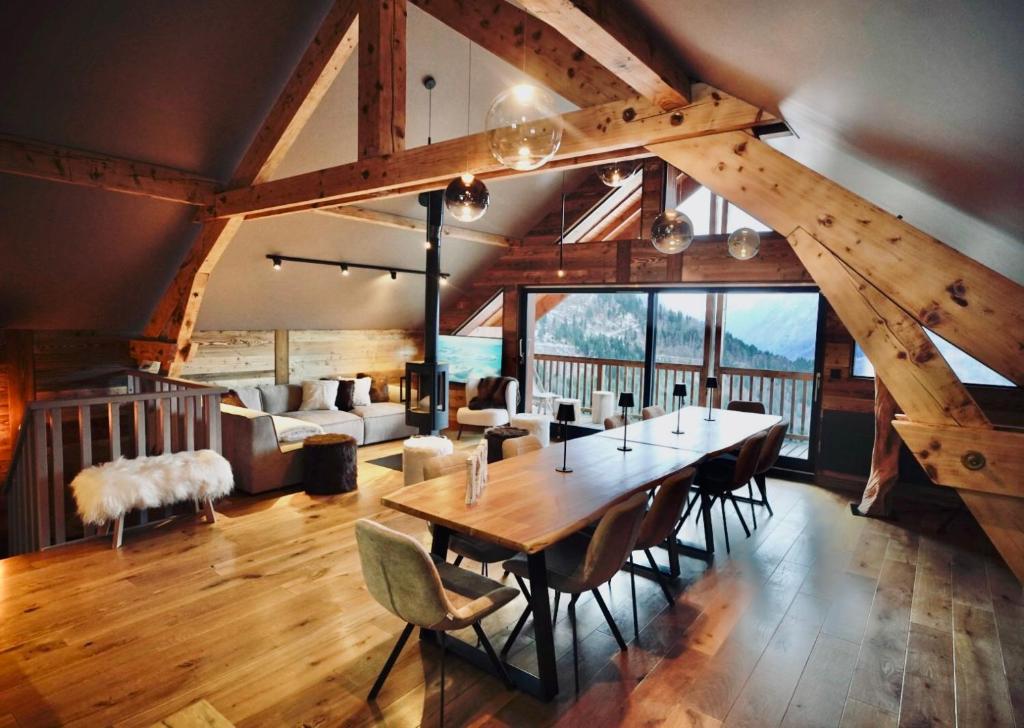 a dining room with a large wooden table and chairs at Moontain Lodge in Oz