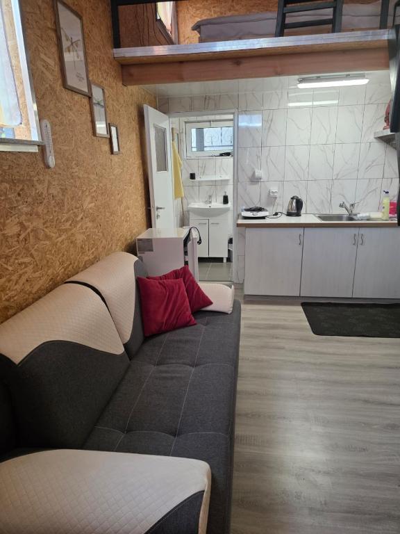 a living room with a couch and a kitchen at Poddasze in Zblewo