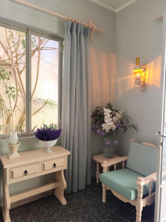 a room with a window and a chair and a table at Pension Alkistis in Tolo