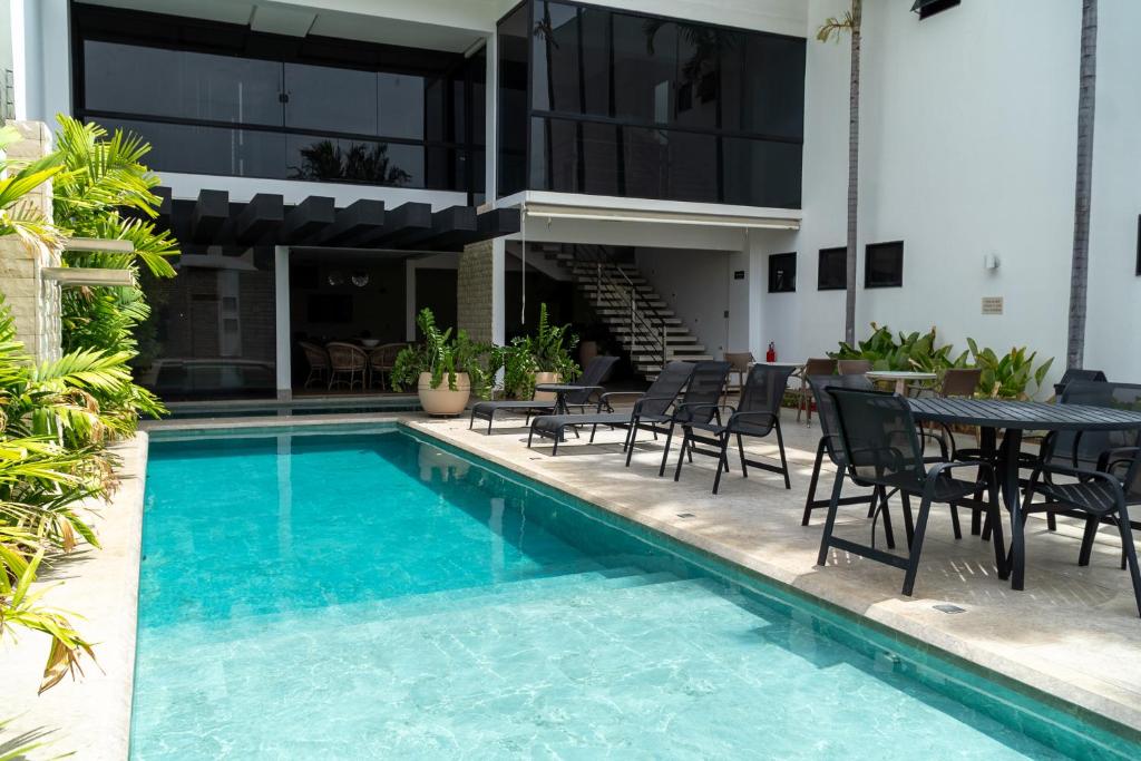 a swimming pool with chairs and a table next to a building at Planaltos Palace Hotel in Goianésia