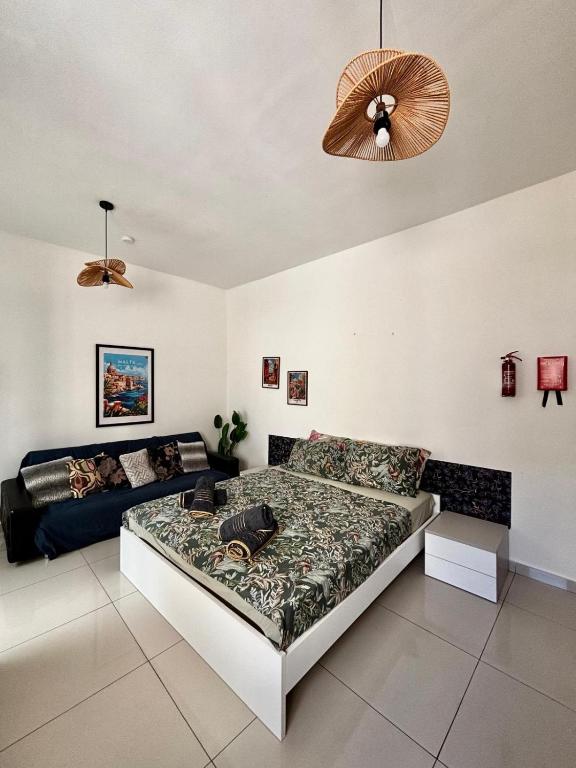 a bedroom with a bed and a couch at Private Room and Own Kitchen Steps to Beach & Nightlife in Sliema