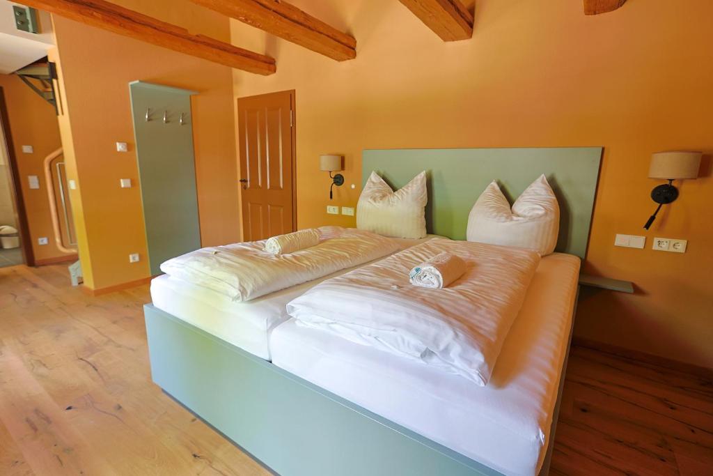 a bedroom with a large bed with white sheets and pillows at Kaffeegarten Am Mühlwerder in Halle an der Saale