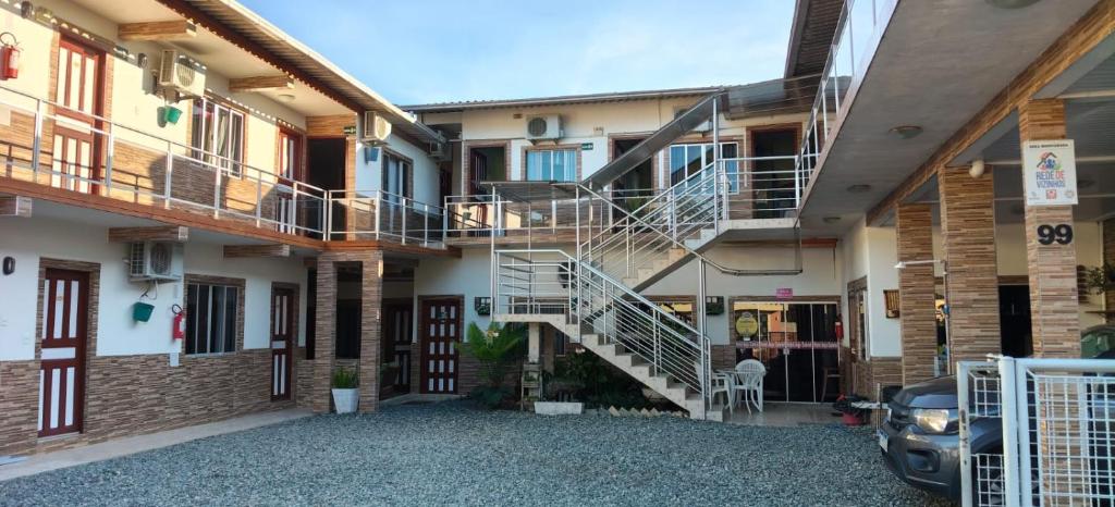 a building with a staircase and a parking lot at Pousada Anjo Gabriel in Penha