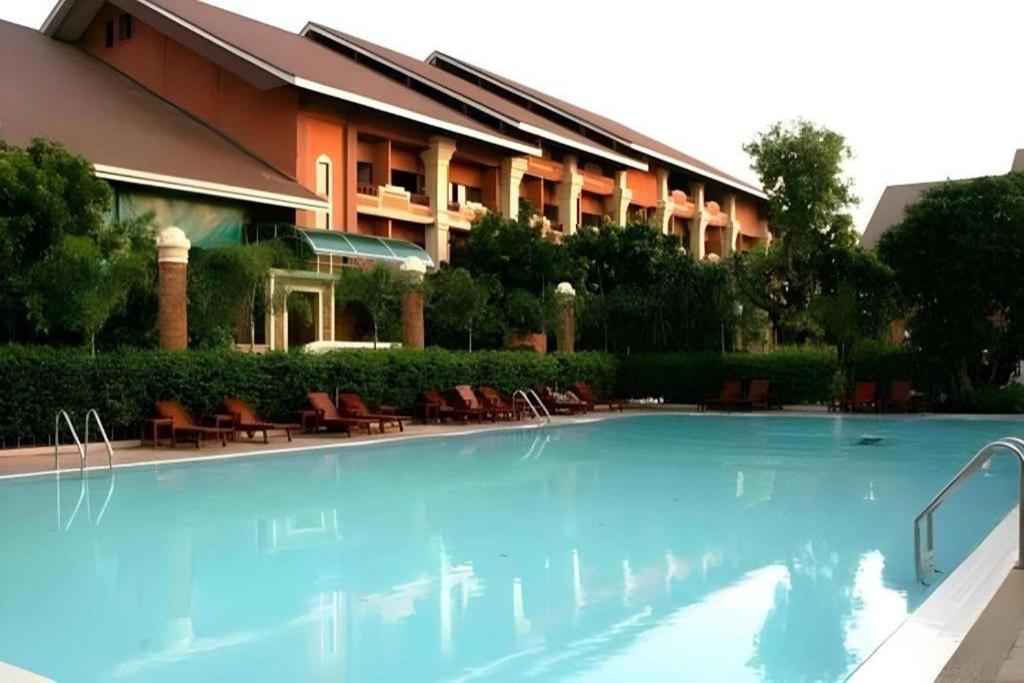 a large swimming pool in front of a building at Fairtex Residence Pattaya in North Pattaya