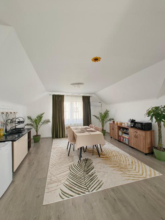 a living room with a table and a kitchen at Chill Garden House in Satu Mare