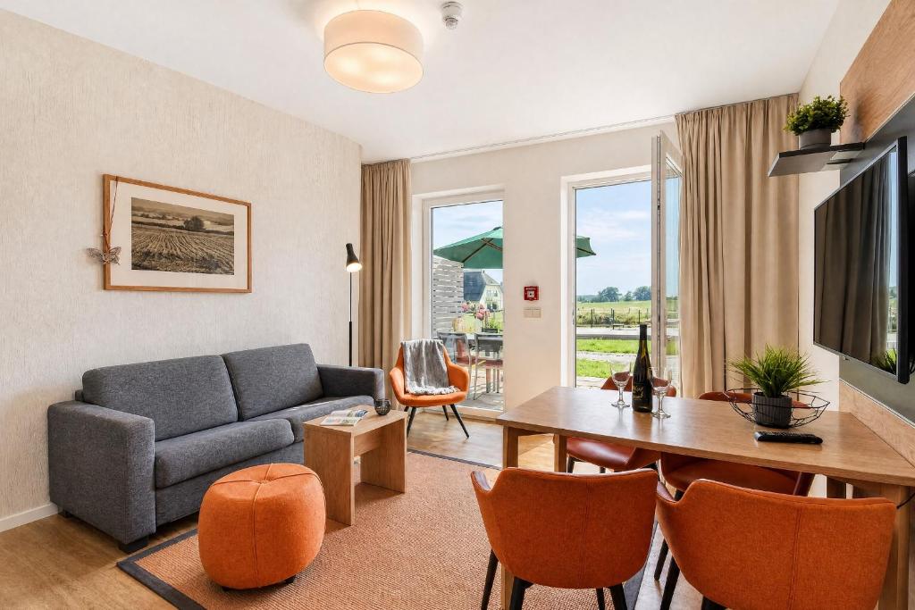 a living room with a couch and a table at Ferienwohnung Grünfink 04 im Wreecher Idyll Rügen by ruyastay in Putbus