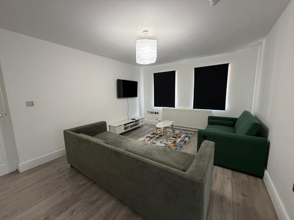 a living room with a couch and a tv at Serene 2-BDR Maisonette in Wolverhampton