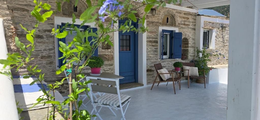 a patio with a blue door and chairs at The Kamaraki Project in Kórthion