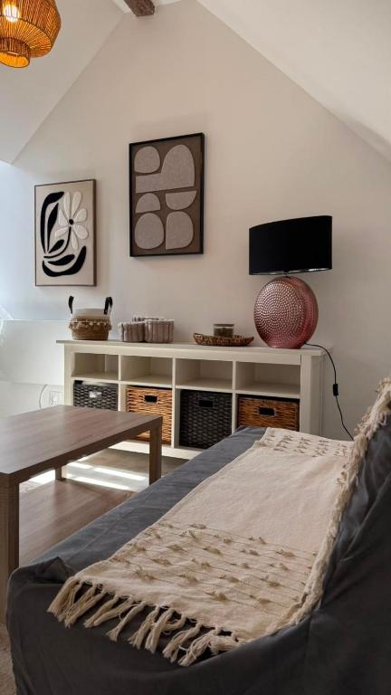 a living room with a bed and a table at Le Cœur de Saint-Aignan in Saint-Aignan