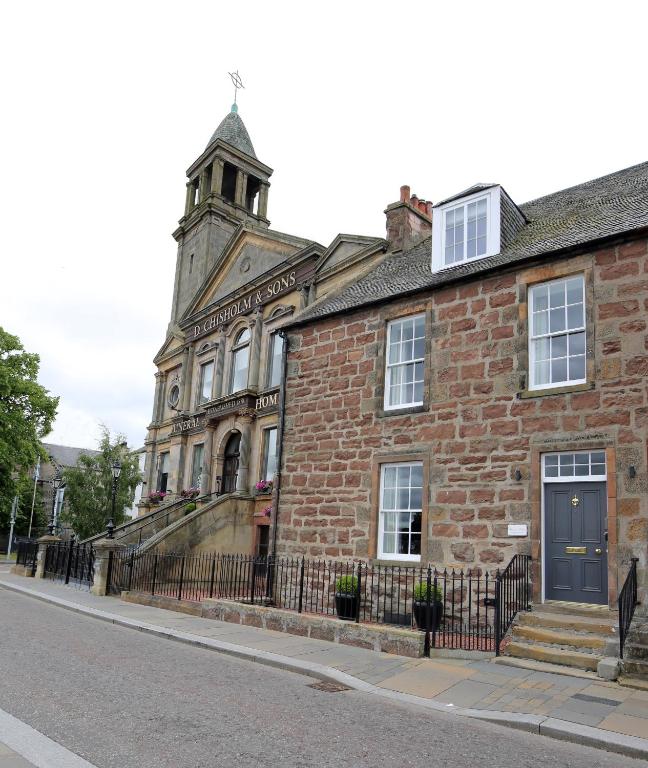 an old brick building with a clock tower on a street at No. 41 Town House in Inverness