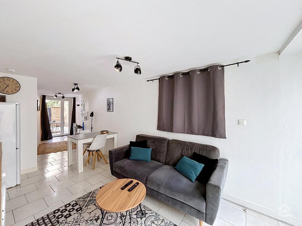 a living room with a couch and a table at Urban Grey - Terrasse - Wifi in Châtellerault
