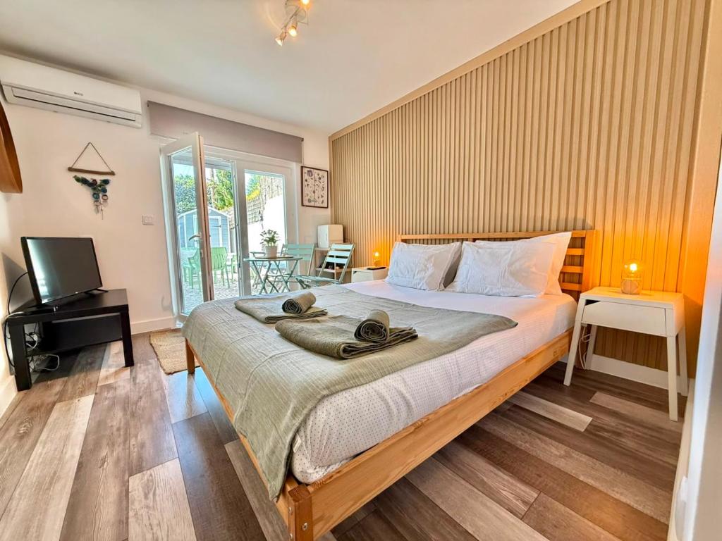 a bedroom with a large bed and a television at IN-Cascais - Suite Deluxe with Terrace & Villa with Pool in Cascais