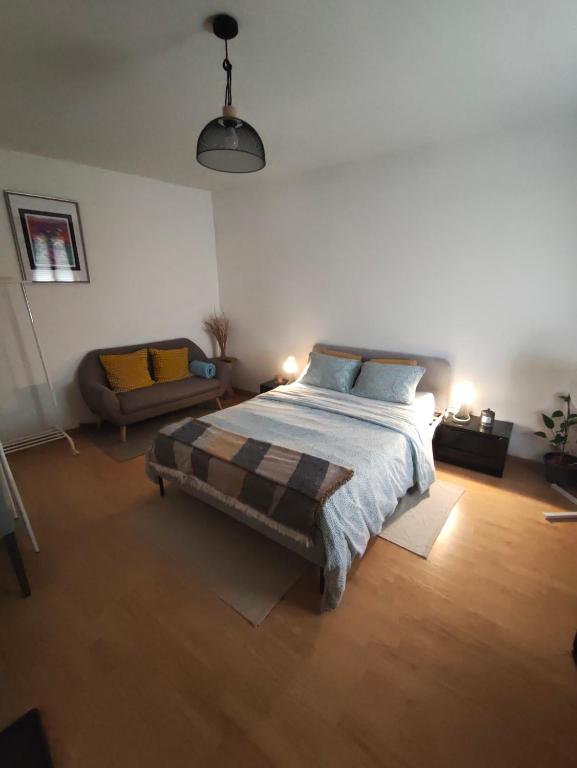 a bedroom with a large bed and a couch at Chambre 1 in Aniche