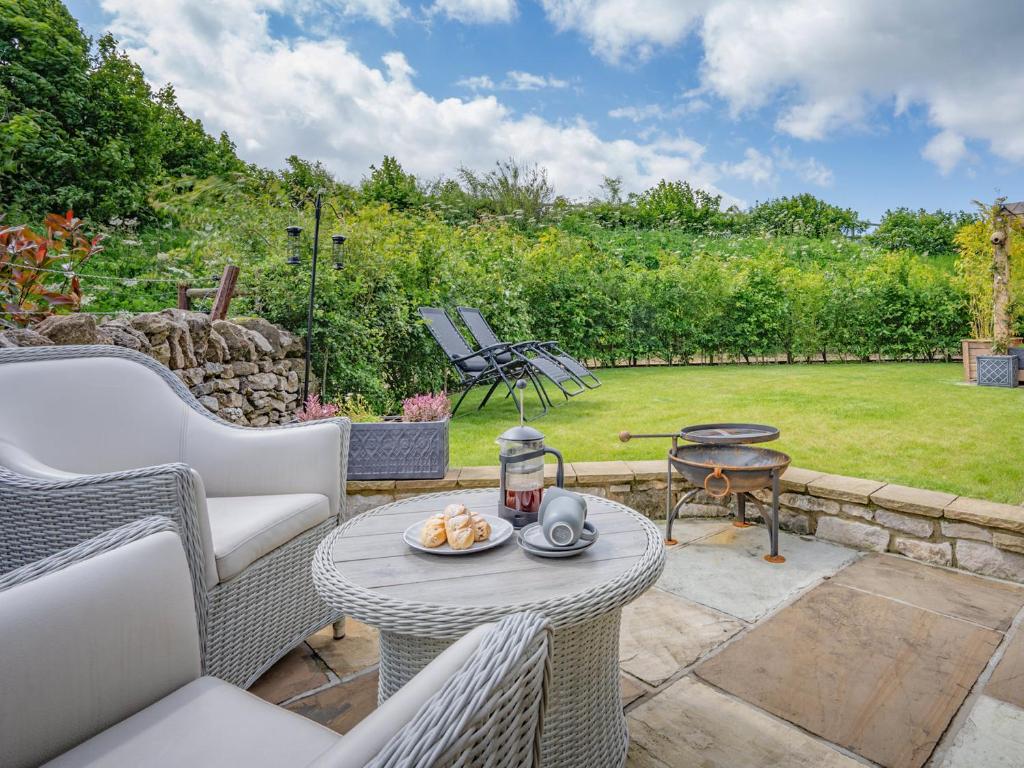 a patio with a table and chairs and a garden at The Cottage - Ukc9711 in Winster