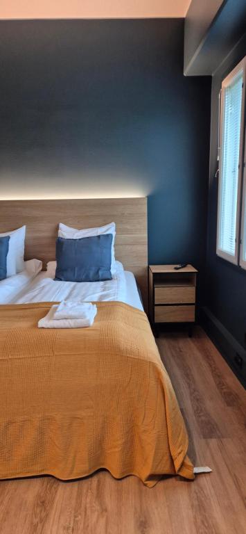 a bedroom with a large bed with blue walls at Hotelli Pato in Nakkila
