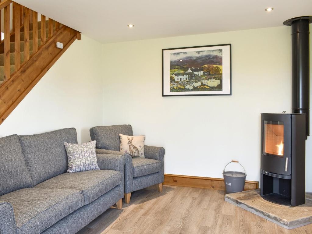 a living room with a couch and a wood stove at Deer Park Barn - Uk33323 in Reeth