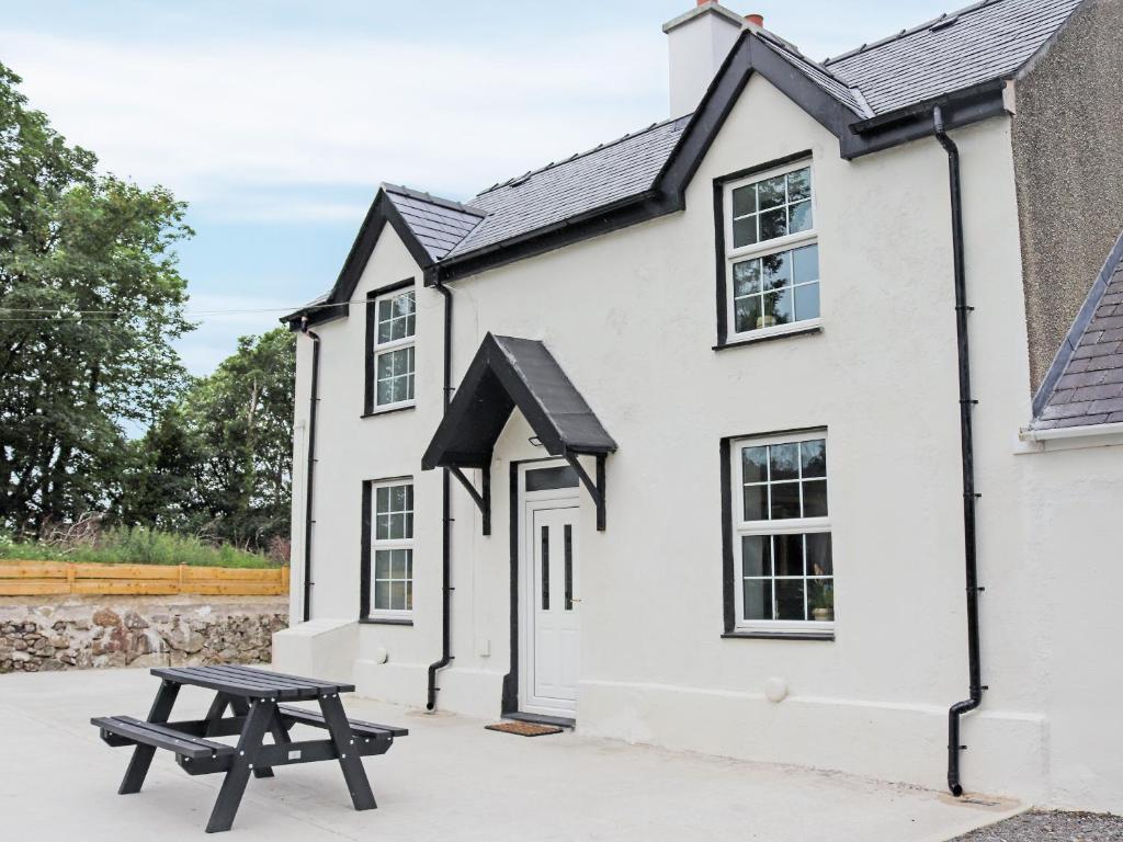 a picnic table in front of a white building at Gate House in Llangefni