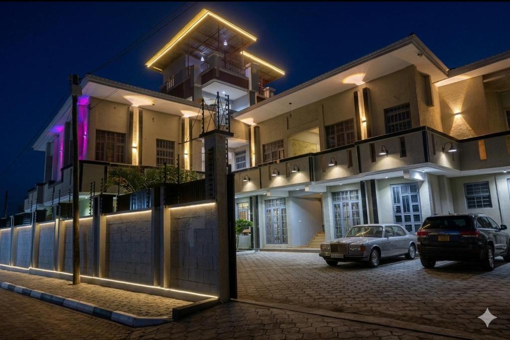 a building with cars parked in front of it at night at NioneEdge-Arusha-Moshono in Themi