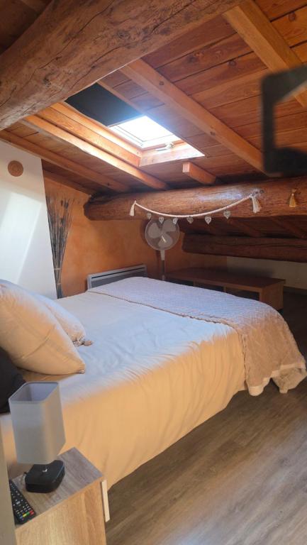 a large bed in a room with wooden ceilings at Mas de chalvagne in Val-de-Chalvagne