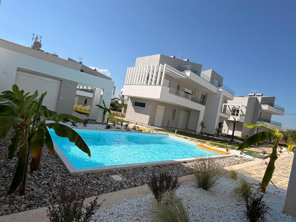 a swimming pool in front of a house at Viasol Suites Thassos in Skala Rachoniou