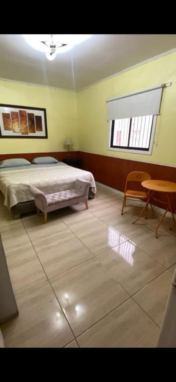 a bedroom with a bed and a table at Hotel Centro in Copiapó
