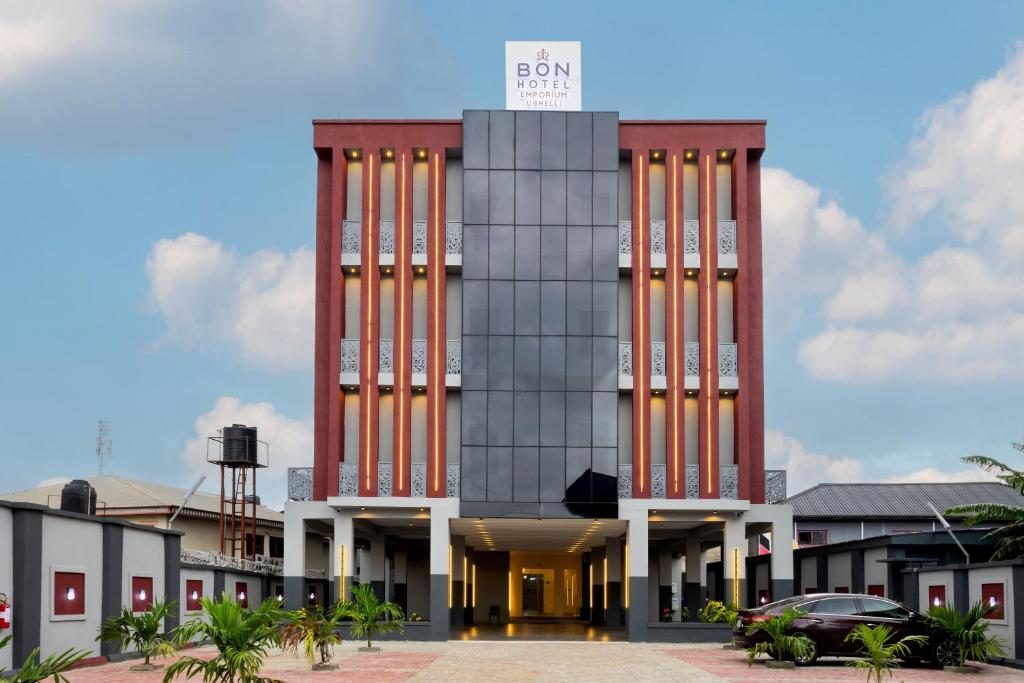a building with orange columns and a sign on top at BON Hotel Emporium in Ughelli