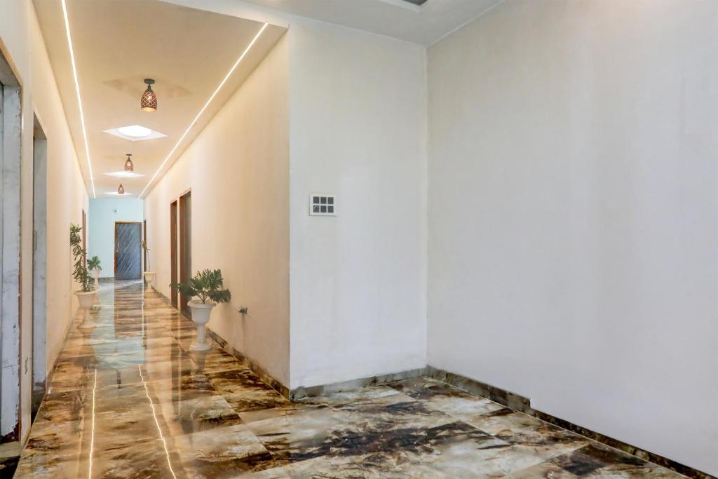 an empty hallway with white walls and marble floors at Hotel O MK2 Hotel and Restaurant in Indore