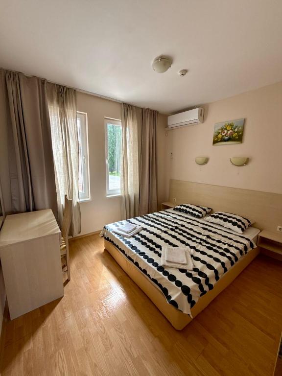 a bedroom with a bed with a black and white comforter at Apartment Amelia in Rogachevo
