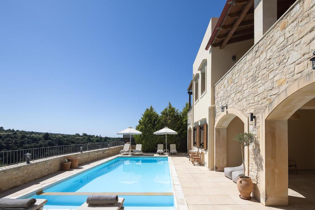 a swimming pool on the side of a building at Ilys Home, a Country-chic Retreat with Pool & BBQ, By ThinkVilla in Margarítai