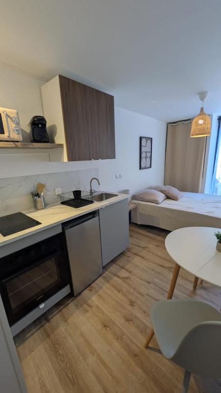 a room with a kitchen and a bedroom with a bed at Le Bourg in Lagnieu