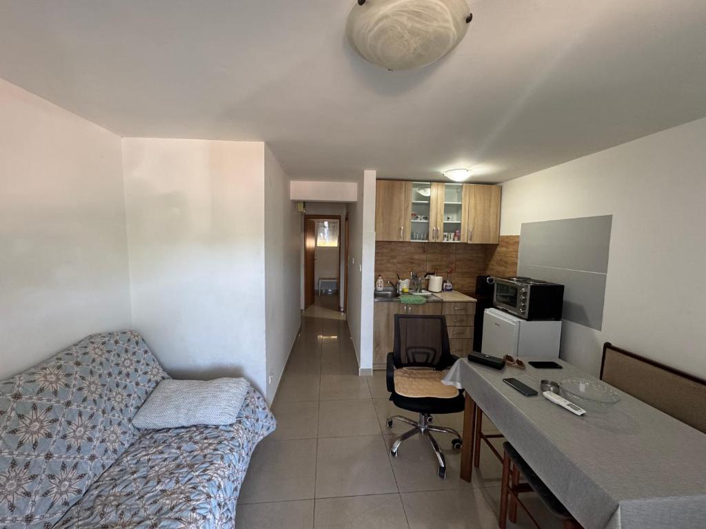 a small room with a bed and a desk in it at Astra Apartment in Meljine