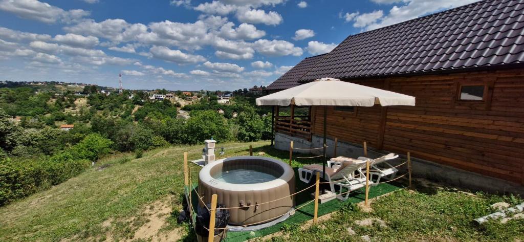 a hot tub on the side of a building with an umbrella at Vikendica Monte in Ledinci