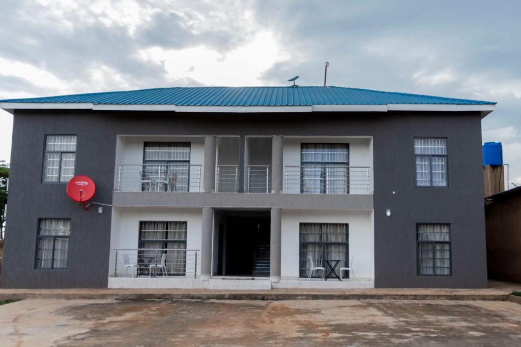 a gray building with a blue roof and a red ball at Mlambe Executive Apartments in Lilongwe