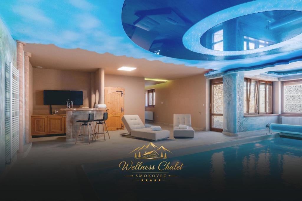 a living room with a swimming pool and a house at Wellness chalet Smokovec in Vysoké Tatry