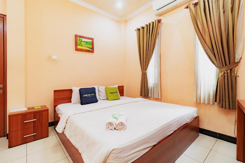 a bedroom with a bed and a window at Urbanview My Grand Hotel Bogor in Brujul