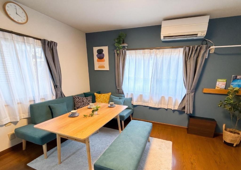 a dining room with a wooden table and blue chairs at ゲストハウス あぽわん 貸切宿無料駐車場 in Mitoyo