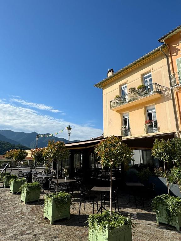 a building with tables and chairs in front of it at Ostan Hôtel Boutique in Roquebillière