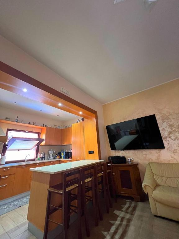 a kitchen with a bar and a flat screen tv at Casa Vacanze PIAZZETTA in San Nico
