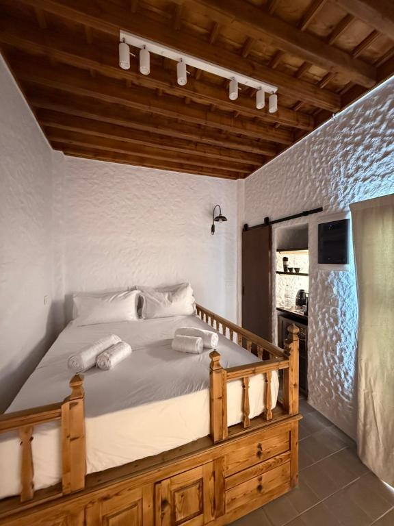 a bedroom with a large bed with a wooden frame at Apollino Lindos in Lindos