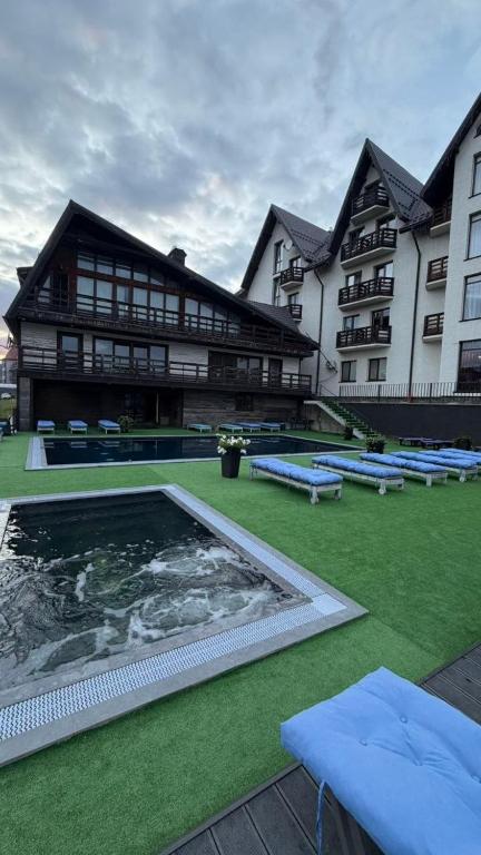 a building with a swimming pool in front of it at Villa Blanc in Bukovel