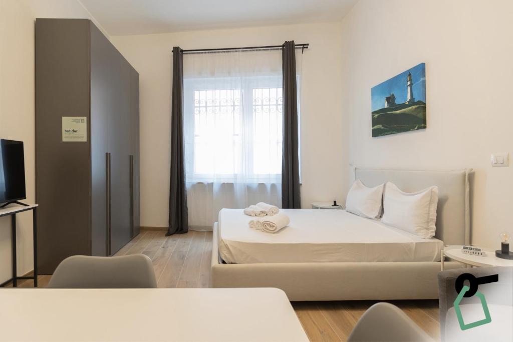 a bedroom with a large bed and a window at Collegno Cozy Apartments in Turin