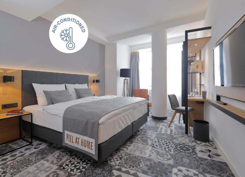 a bedroom with a bed and a desk and a tv at Coffee Fellows Hotel Dortmund in Dortmund