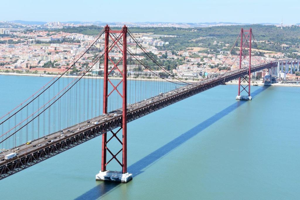 an aerial view of a bridge over the water at Only 10 min from Lisbon city centre, 15 min driving from the beaches! in Almada