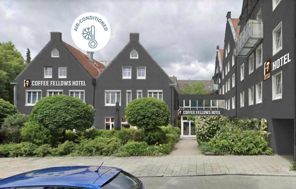 a blue car parked in front of a building at Coffee Fellows Hotel Puchheim in Puchheim