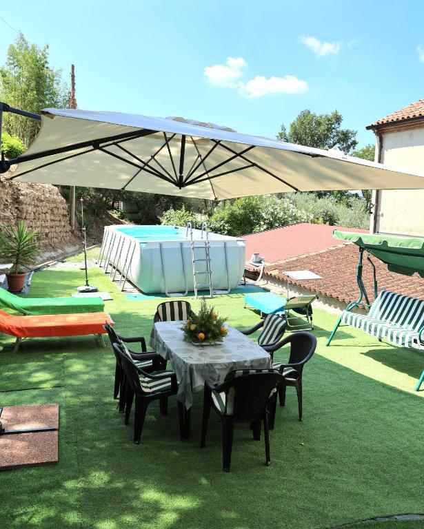 a table and chairs under an umbrella in a yard at Locanda di Cornoleda in Cinto Euganeo