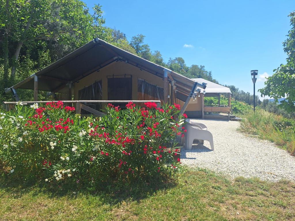 a cabin with a black roof with red flowers at casavistafiore in Montefiore dellʼAso